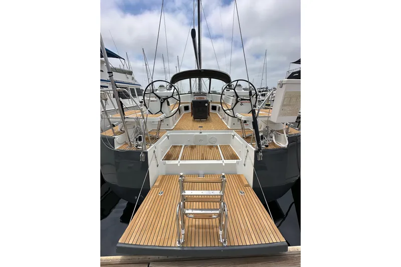  Yacht Photos Pics 2018 Jeanneau 54 yacht with dual steering wheels and teak deck in a marina.
