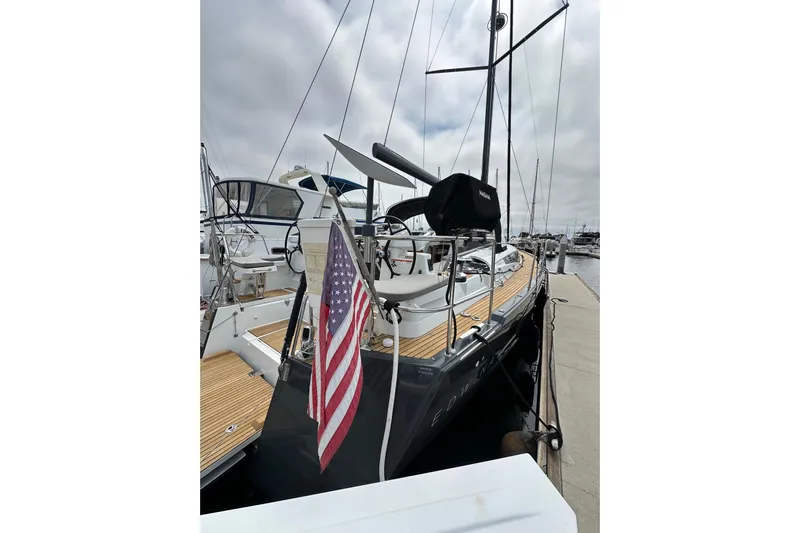  Yacht Photos Pics 2018 Jeanneau 54 yacht docked with American flag, showcasing sleek design and spacious deck.
