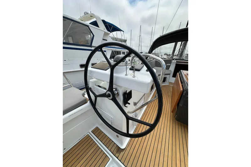  Yacht Photos Pics Steering wheel of a 2018 Jeanneau 54 yacht, featuring teak decking and modern design.