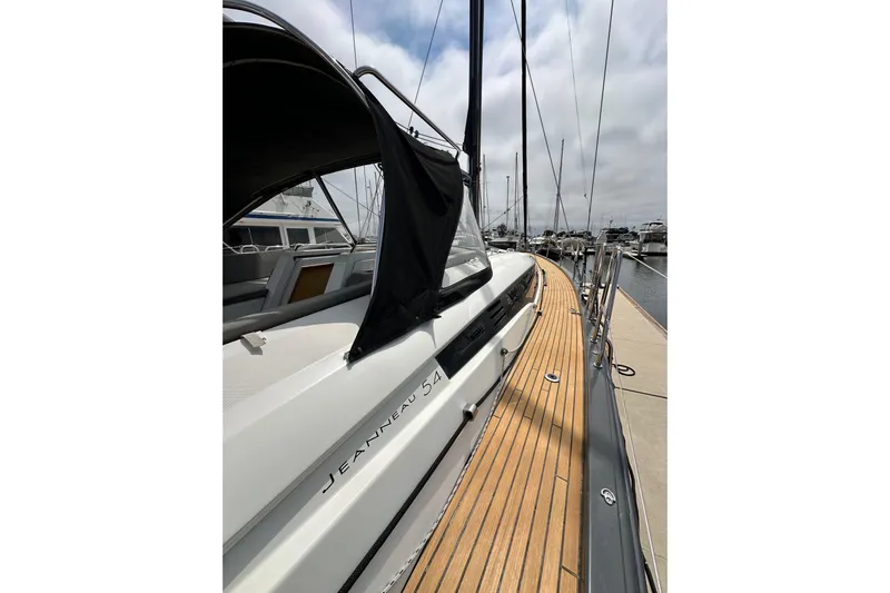  Yacht Photos Pics 2018 Jeanneau 54 yacht docked, showcasing sleek design and wooden deck.