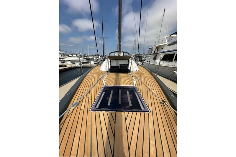  Yacht Photos Pics 2018 Jeanneau 54 yacht with teak deck, docked in marina under blue sky.