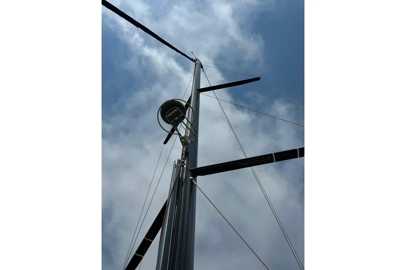  Yacht Photos Pics Mast of 2018 Jeanneau 54 sailboat against a cloudy sky.