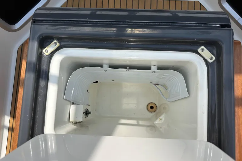  Yacht Photos Pics Open storage compartment on 2018 Jeanneau 54 yacht, featuring white interior and metal hinges.
