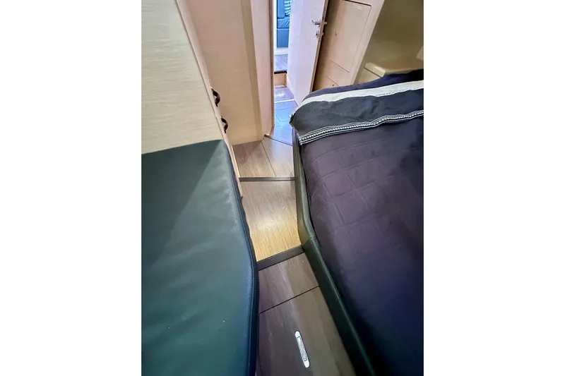  Yacht Photos Pics Interior cabin view of 2018 Jeanneau 54 yacht, featuring sleek wood flooring and cozy bedding.