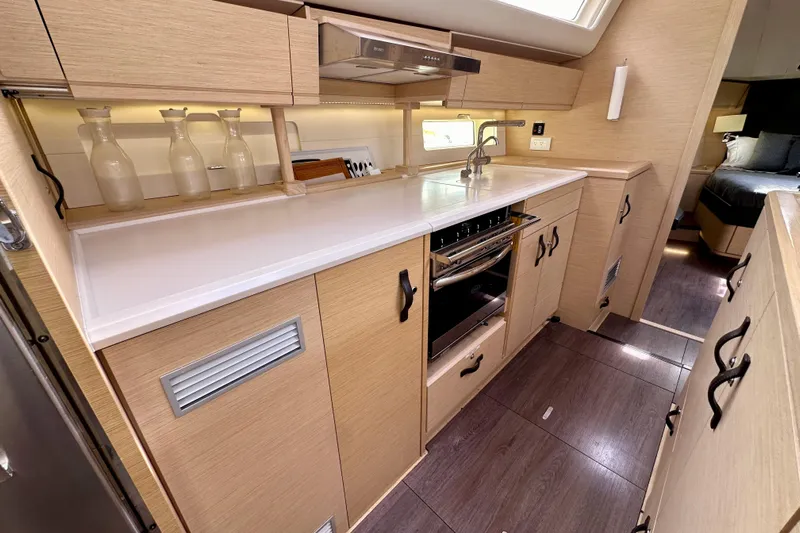  Yacht Photos Pics Modern kitchen interior of 2018 Jeanneau 54 yacht with sleek cabinetry and appliances.