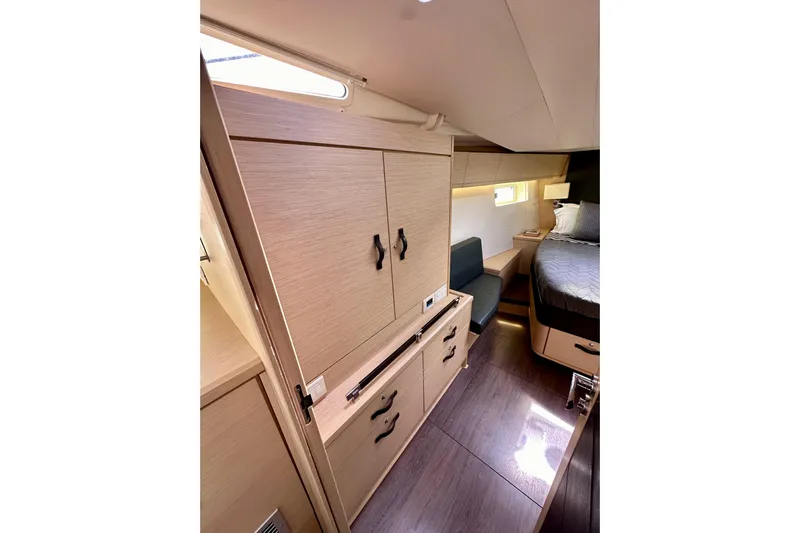  Yacht Photos Pics Luxurious interior of 2018 Jeanneau 54 yacht with modern wood cabinetry and cozy sleeping area.