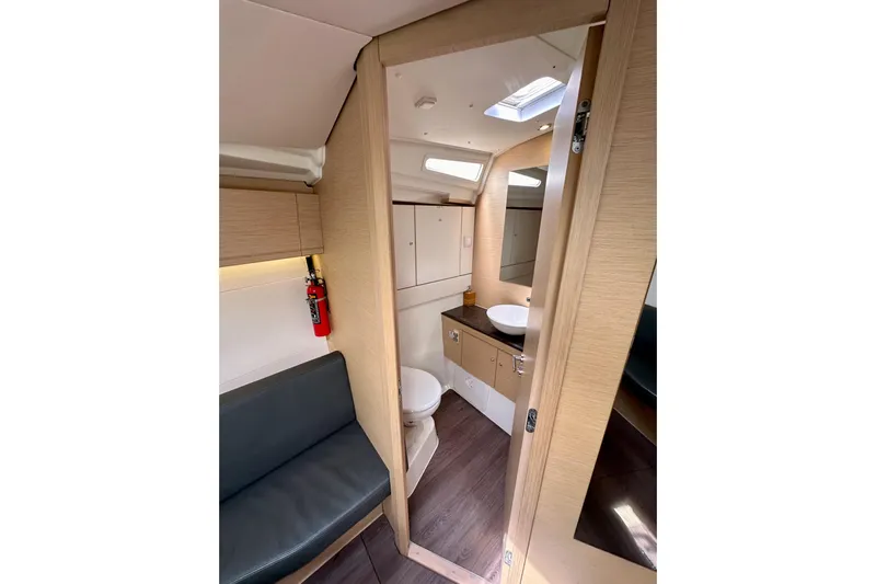  Yacht Photos Pics Interior of 2018 Jeanneau 54 yacht showing bathroom and seating area.