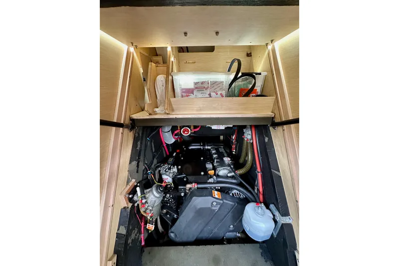  Yacht Photos Pics Engine compartment of a 2018 Jeanneau 54 sailboat, showcasing mechanical components and storage.