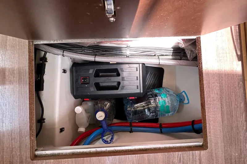 Yacht Photos Pics Storage compartment in a 2018 Jeanneau 54 yacht with cables and water bottles.