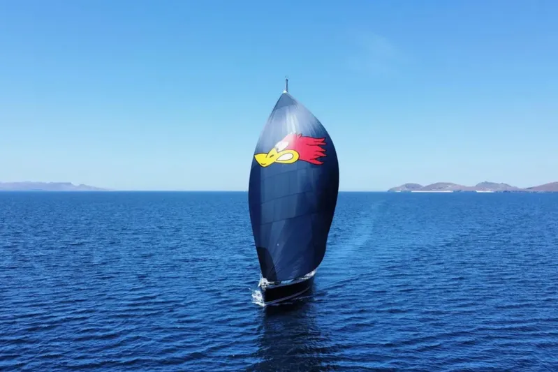  Yacht Photos Pics Jeanneau 54 sailboat with colorful spinnaker sailing on open sea, 2018 model.