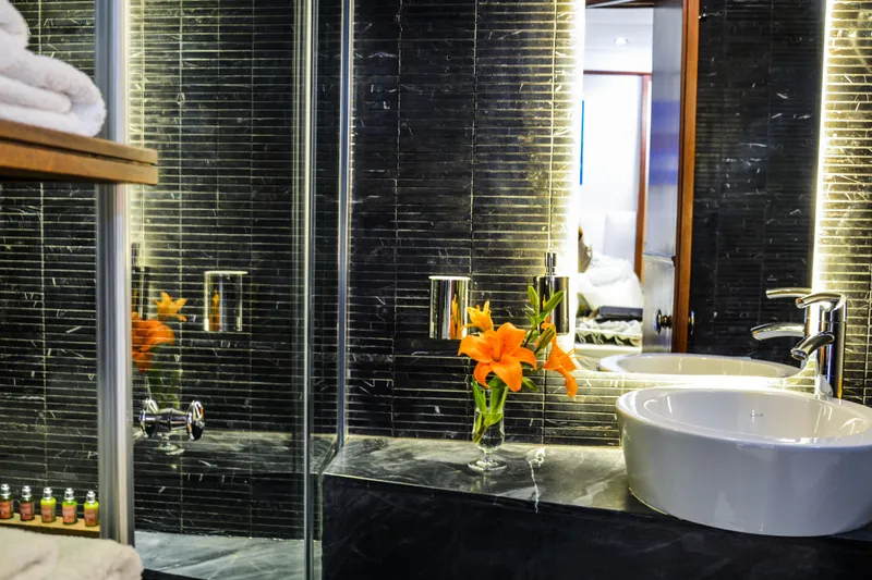 Papa Joe Yacht Photos Pics Luxurious bathroom on 2007 Mastori Gulet yacht with modern sink and vibrant orange flowers.