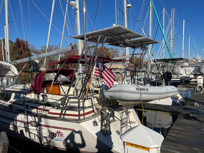 Lizette Yacht Photos Pics Sailboat docked at marina, Regina 43 model, 2000, with American flag and dinghy.