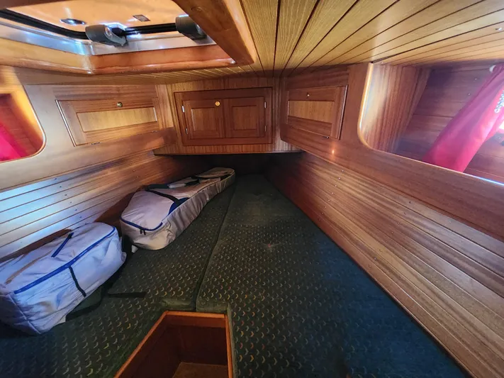 Lizette Yacht Photos Pics Wood-paneled cabin interior of a 2000 Regina 43 boat, featuring storage compartments and bags.