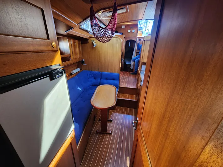 Lizette Yacht Photos Pics Interior of a 2000 Regina 43 sailboat with wooden finish and blue seating.