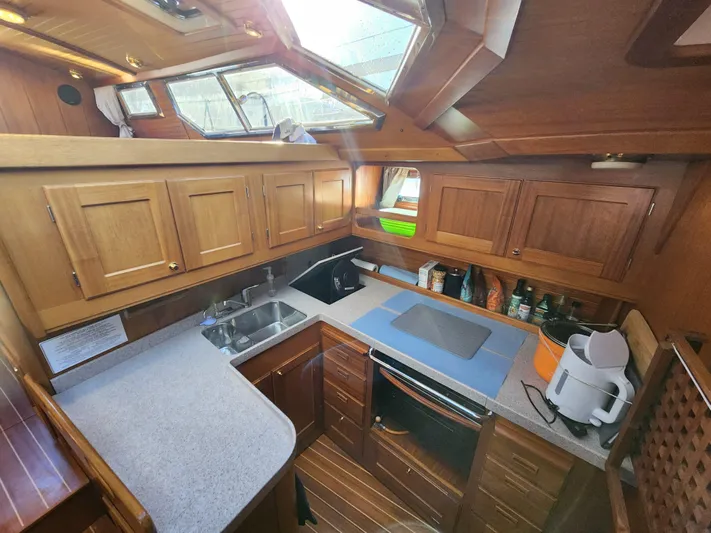 Lizette Yacht Photos Pics Luxurious Regina 43 yacht kitchen, 2000 model, featuring wooden cabinetry, modern appliances, and ample counter space.