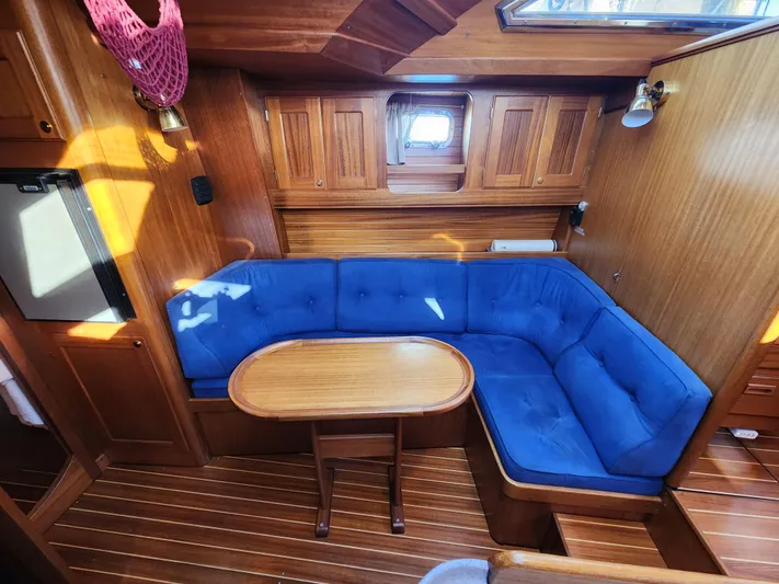 Lizette Yacht Photos Pics Cozy wooden yacht interior with blue cushioned seating, Regina 43 model, 2000.
