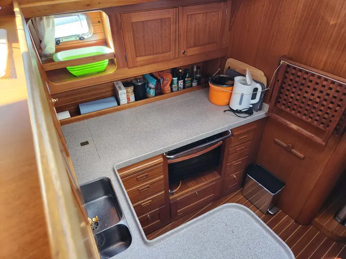 Lizette Yacht Photos Pics Compact kitchen in a 2000 Regina 43 yacht with wooden cabinets and modern appliances.
