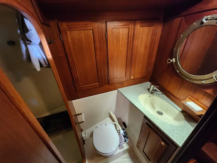 Lizette Yacht Photos Pics Wooden boat bathroom with sink, toilet, and porthole window. Regina 43, year 2000.