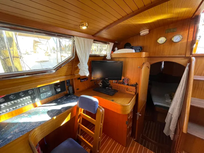 Lizette Yacht Photos Pics Cozy interior of 2000 Regina 43 sailboat with wooden finish, desk, and sleeping area.