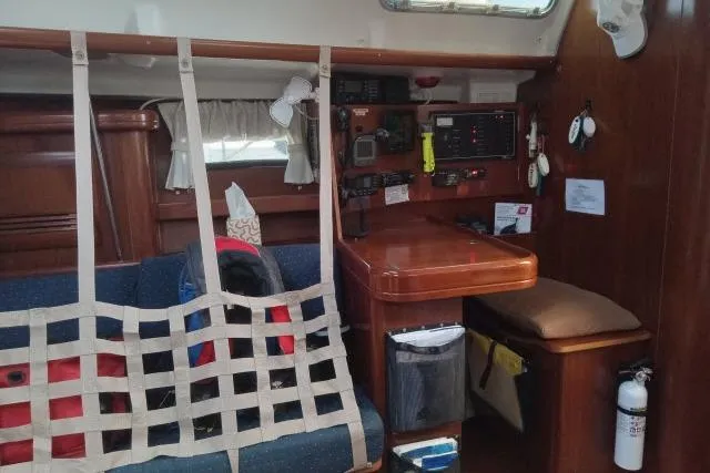 Pacifico Yacht Photos Pics Interior of a 2005 Beneteau 393 sailboat with navigation station and seating area.