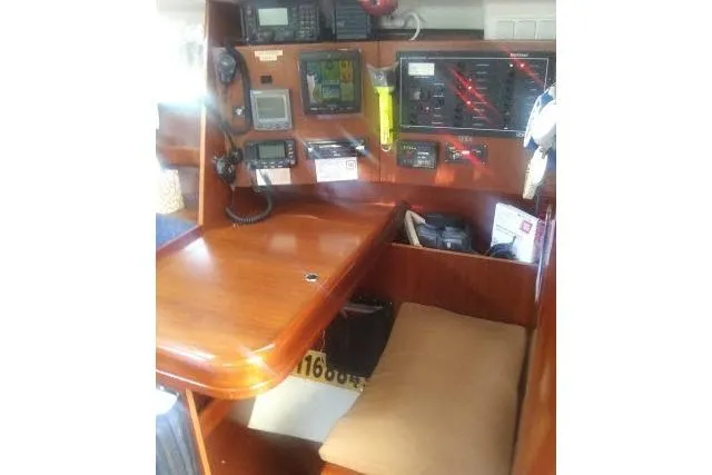 Pacifico Yacht Photos Pics Navigation station inside 2005 Beneteau 393 yacht with communication equipment and wooden desk.