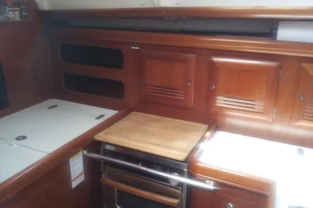Pacifico Yacht Photos Pics 2005 Beneteau 393 yacht kitchen with wooden cabinets and stove.