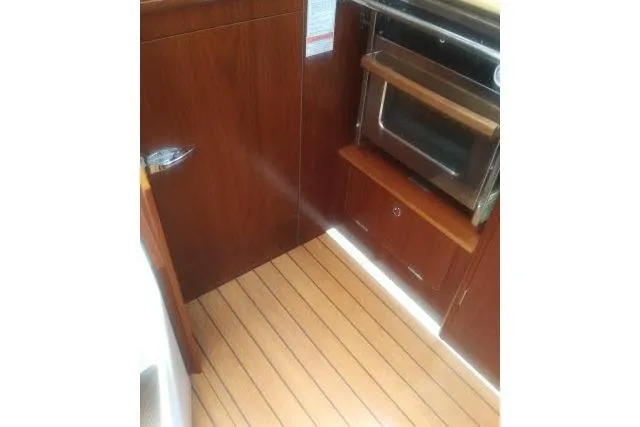 Pacifico Yacht Photos Pics Interior of 2005 Beneteau 393 yacht showing wooden cabinetry and built-in oven.