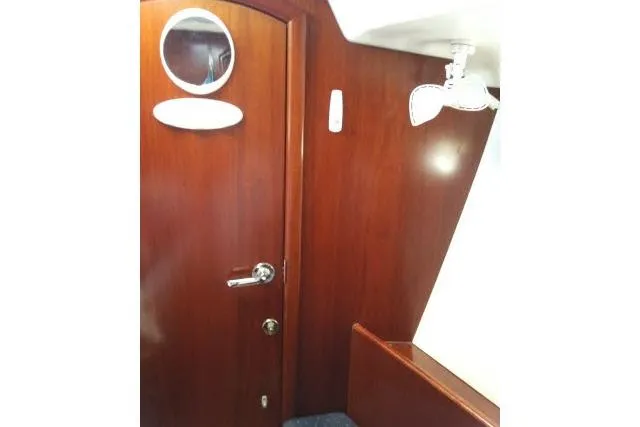 Pacifico Yacht Photos Pics Interior of 2005 Beneteau 393 yacht with wooden door and porthole.