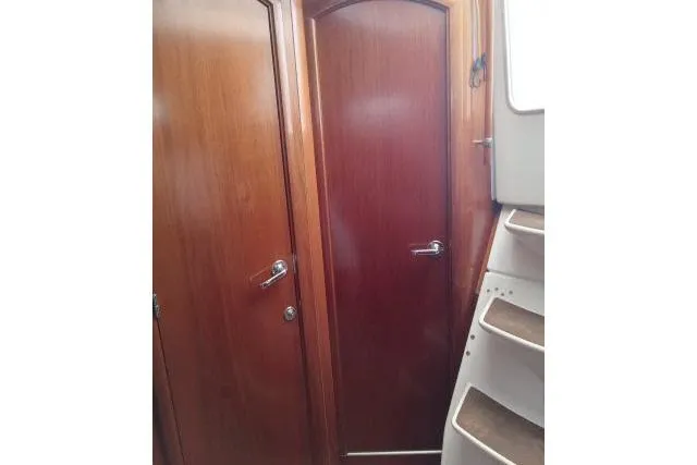 Pacifico Yacht Photos Pics Interior view of 2005 Beneteau 393 yacht, featuring wooden doors and staircase.