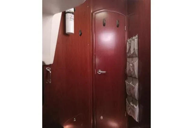 Pacifico Yacht Photos Pics Interior of 2005 Beneteau 393 yacht with wooden door and storage pockets.