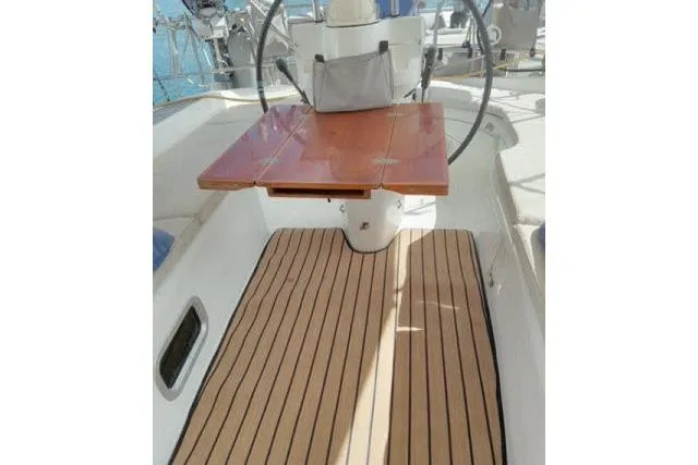 Pacifico Yacht Photos Pics 2005 Beneteau 393 yacht cockpit with wooden table and striped flooring.