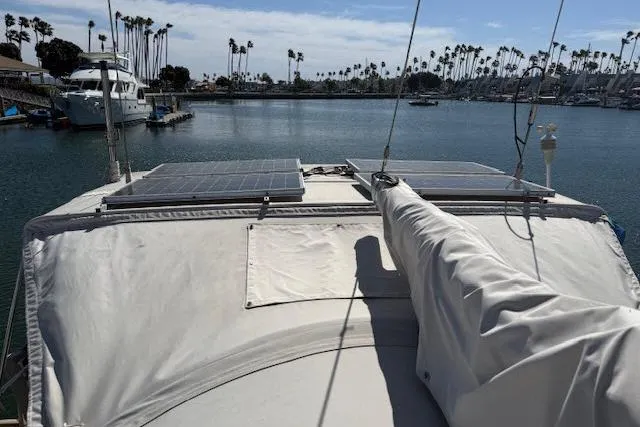 Pacifico Yacht Photos Pics Sailboat Beneteau 393 (2005) with solar panels docked in a marina.