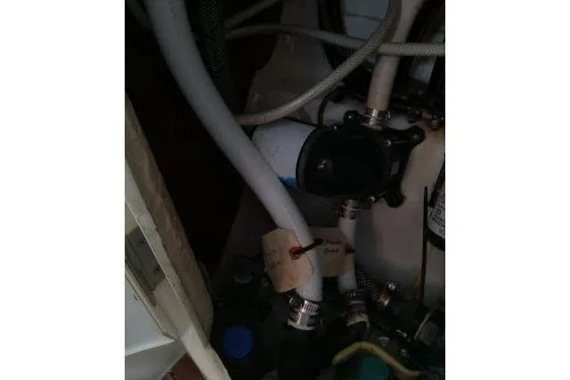 Pacifico Yacht Photos Pics Engine compartment of a 2005 Beneteau 393 sailboat, showing hoses and mechanical components.