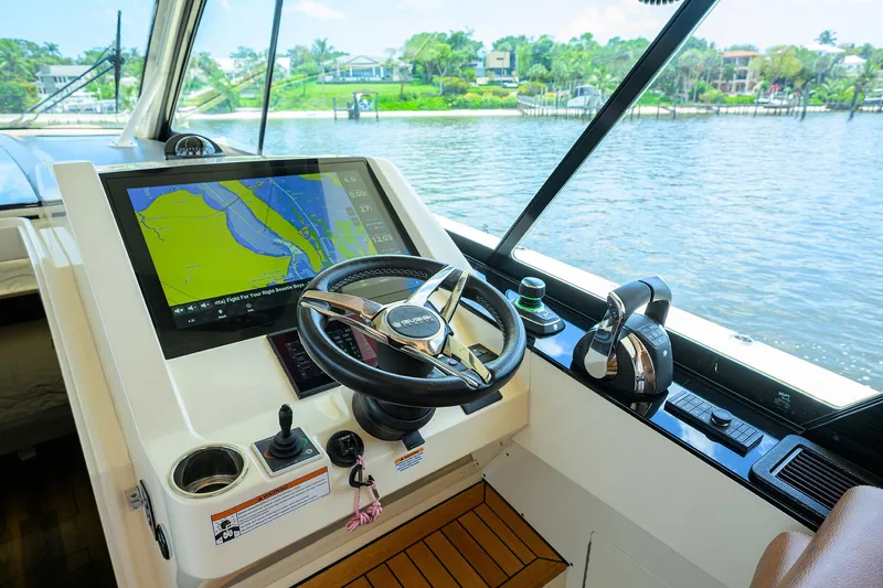 53 Scout Yacht Photos Pics 2021 Scout 530 LXF helm with navigation display, steering wheel, and scenic water view.