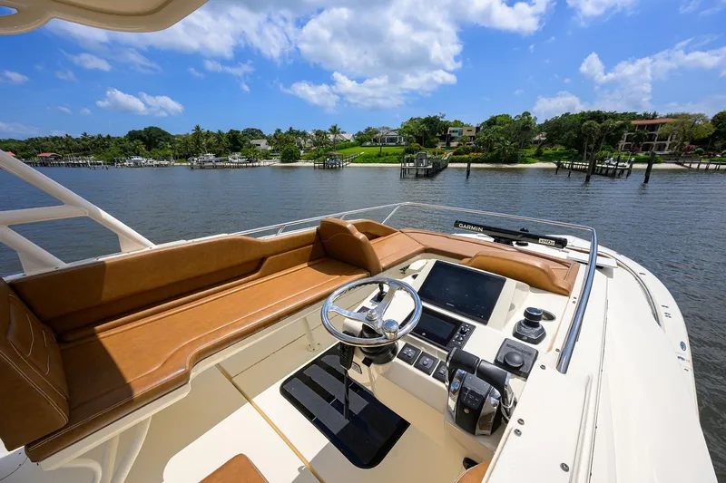 53 Scout Yacht Photos Pics 2021 Scout 530 LXF boat helm with luxurious seating and advanced controls, docked by scenic waterfront.