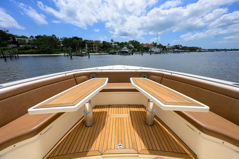 53 Scout Yacht Photos Pics 2021 Scout 530 LXF boat interior with wooden deck and seating, under a blue sky.