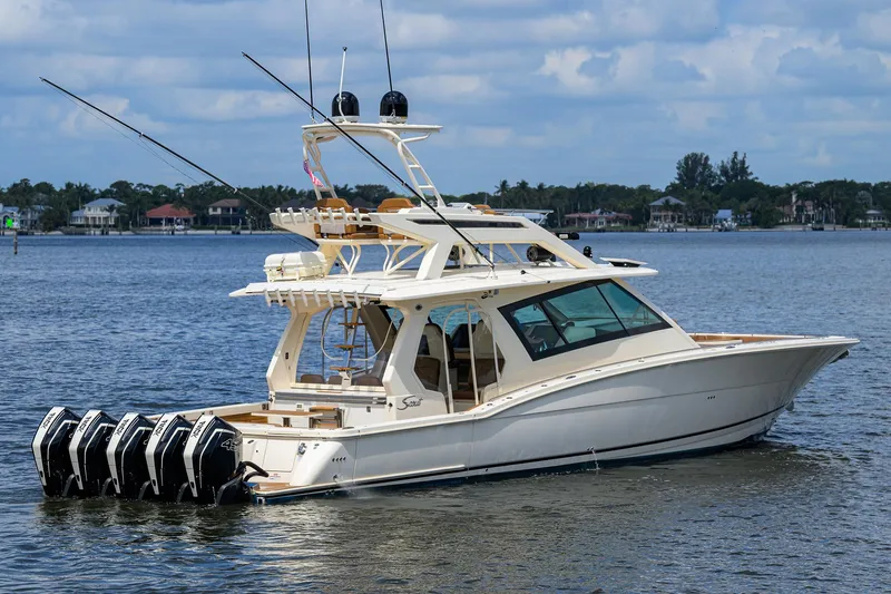 53 Scout Yacht Photos Pics 2021 Scout 530 LXF luxury boat with multiple outboard engines on a calm lake.