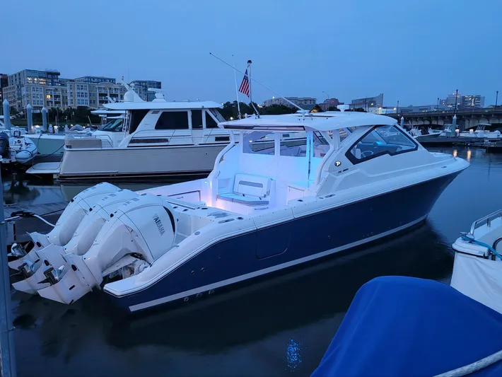  Yacht Photos Pics 2023 Pursuit DC 365 Dual Console boat docked at marina during twilight.