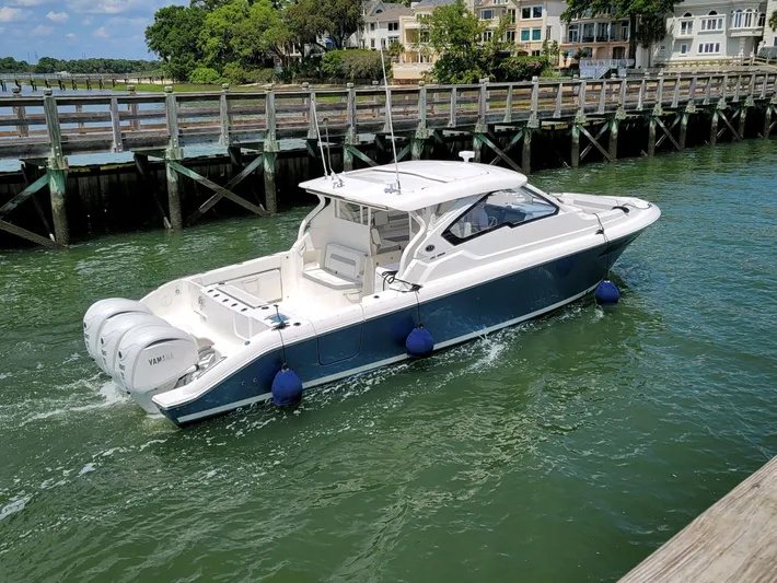  Yacht Photos Pics 2023 Pursuit DC 365 Dual Console boat docked near wooden pier.