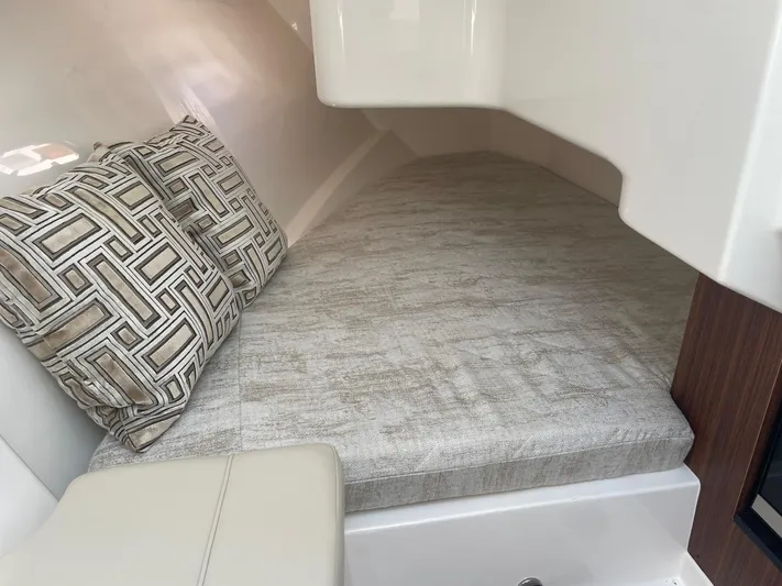  Yacht Photos Pics 2023 Pursuit DC 365 Dual Console cabin interior with cushioned bed and patterned pillows.