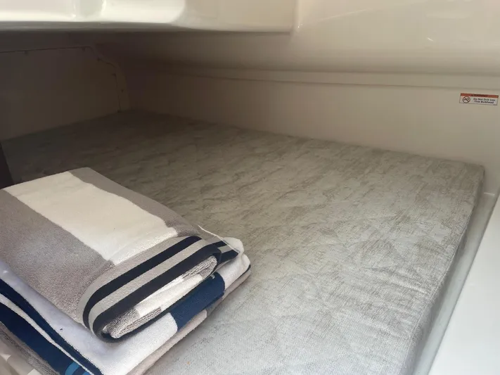 Yacht Photos Pics 2023 Pursuit DC 365 Dual Console cabin with folded towels on a bed.