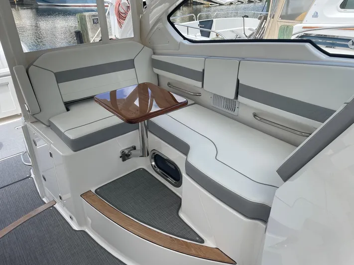  Yacht Photos Pics 2023 Pursuit DC 365 Dual Console interior with sleek seating and wooden table.