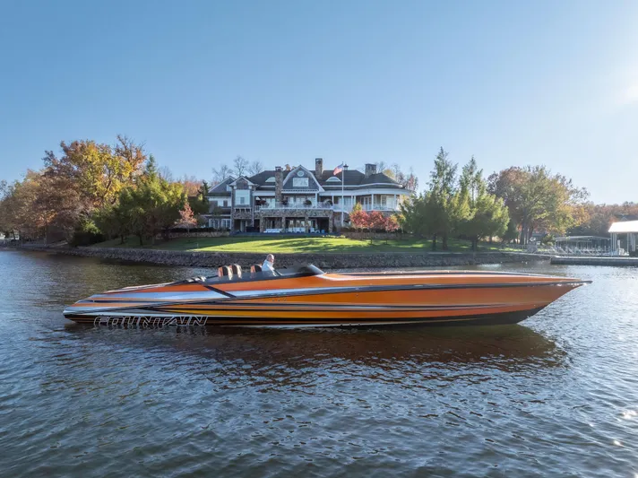  Yacht Photos Pics 2020 Fountain 47 Lightning speedboat on a serene lake near a luxurious house.