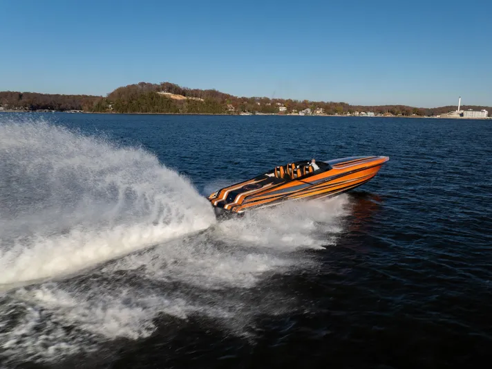  Yacht Photos Pics 2020 Fountain 47 Lightning speedboat racing on a lake, creating a large wake.
