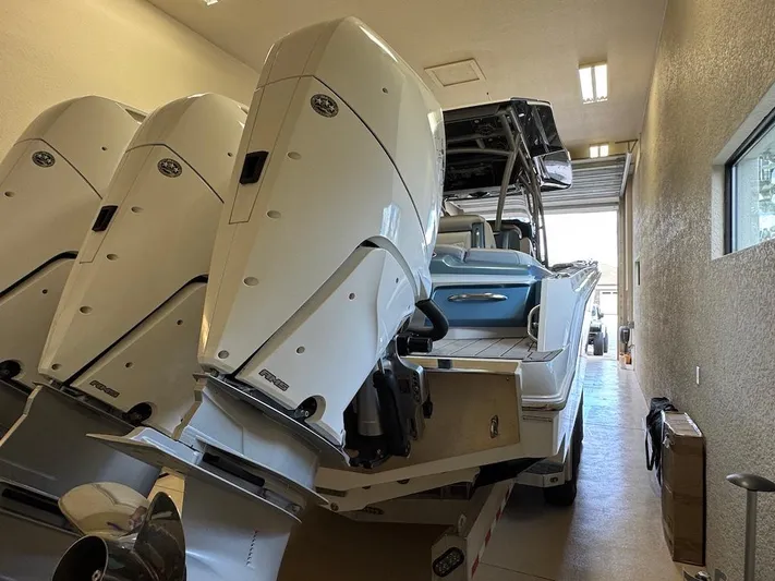  Yacht Photos Pics 2024 Nor-Tech 390 Sport Center Console with triple outboard engines in a garage.