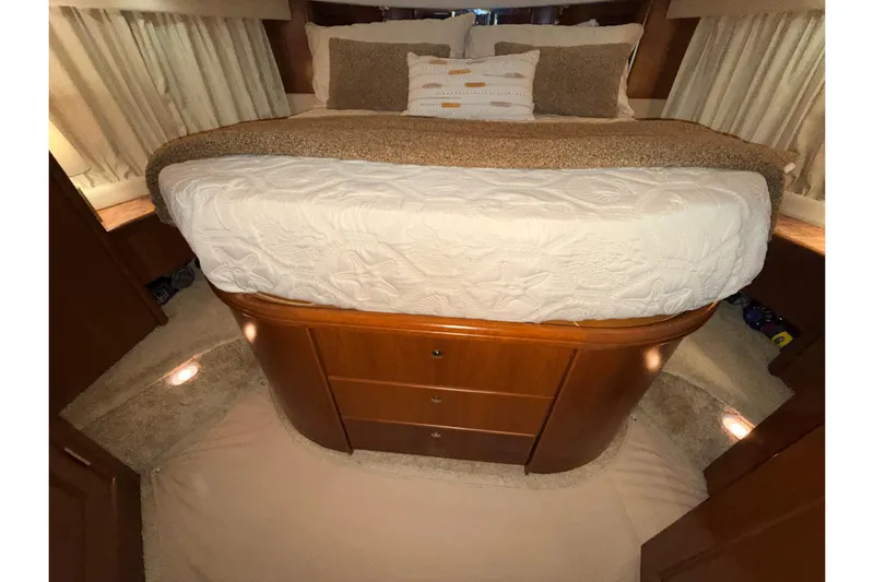Bellissimo Yacht Photos Pics Interior cabin of 2006 Silverton 38 Sport Bridge with cozy bed and wooden cabinetry.