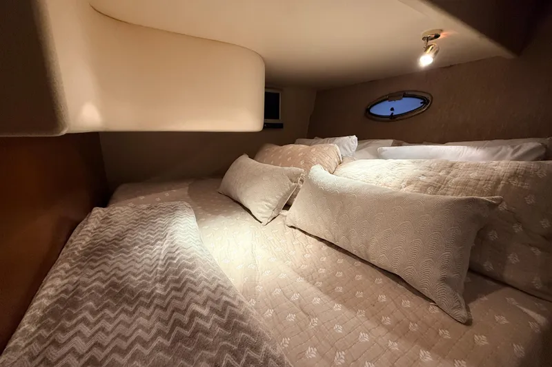 Bellissimo Yacht Photos Pics Cozy cabin interior of 2006 Silverton 38 Sport Bridge with plush bedding and soft lighting.