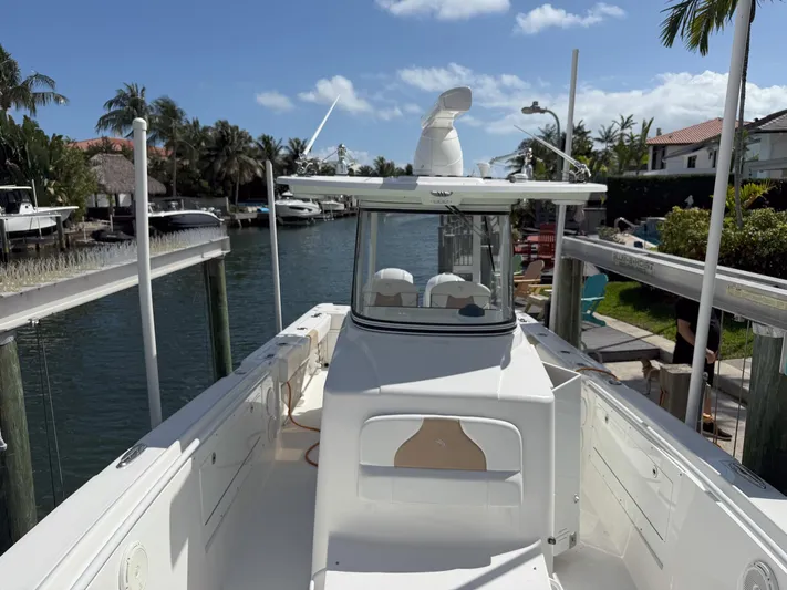 Dan's Seachelle Yacht Photos Pics 2019 Edgewater 320CC boat docked in a scenic canal with palm trees.