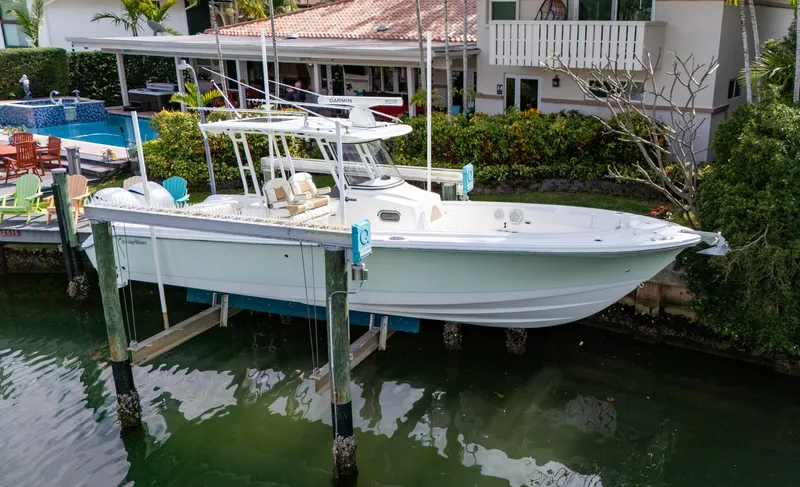 Dan's Seachelle Yacht Photos Pics 2019 Edgewater 320CC boat docked near waterfront home.