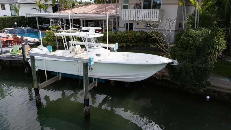 Dan's Seachelle Yacht Photos Pics 2019 Edgewater 320CC boat docked near waterfront home.